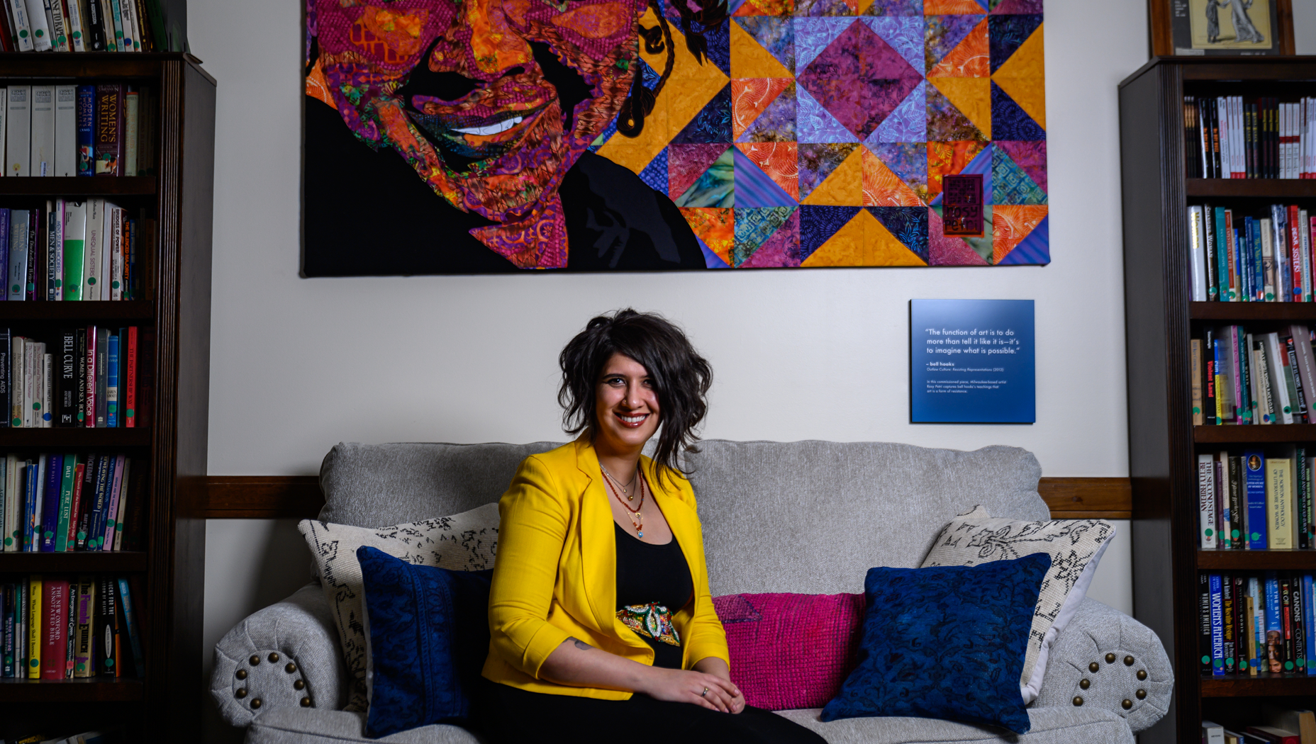 M. Shadee Malaklou sitting on a couch in a library.