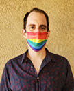 Photo of James Vitiello wearing a rainbow mask in front of a tan wall