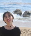 Xiangu Qi smiling on the beach