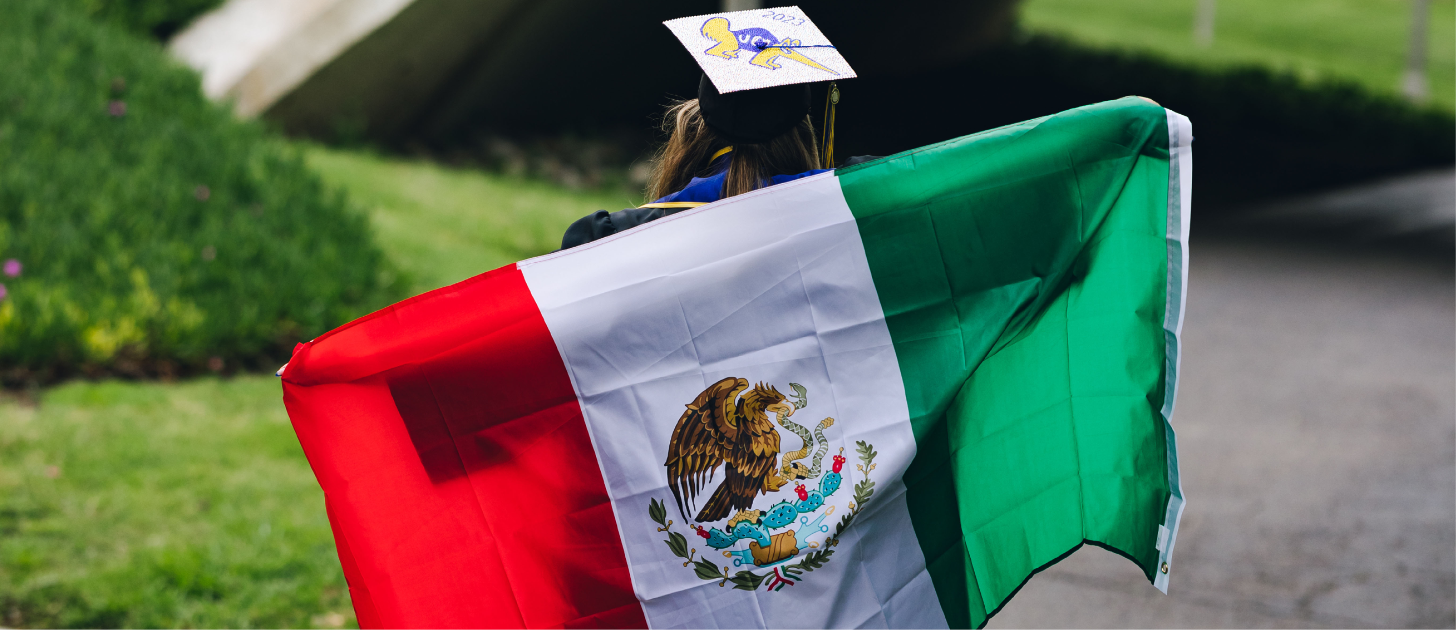 A woman with a graduation cap and the Mexican flag.