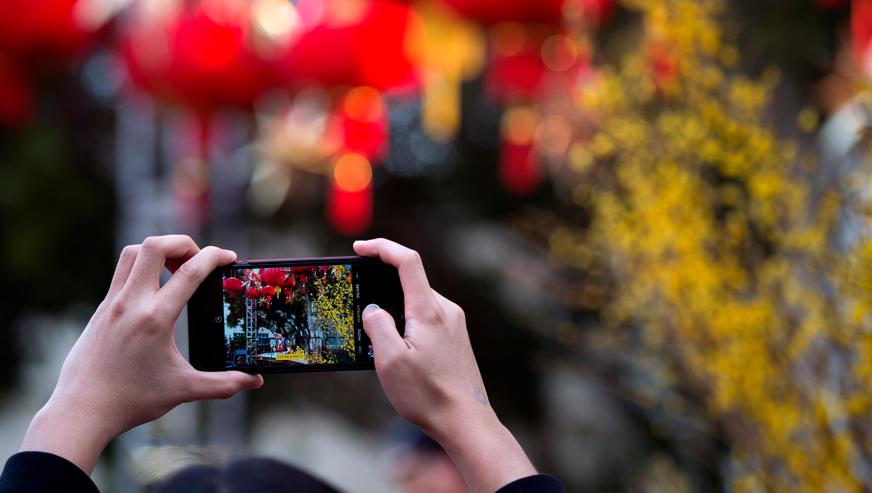 A student taking a picture during a Lunar New Year Celebration