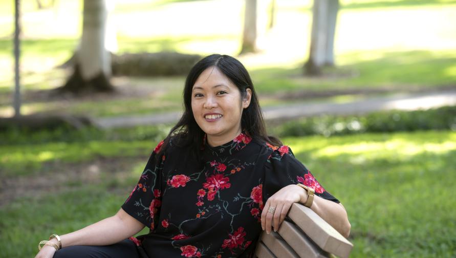 Adria Imada sits on a bench in Aldrich Park