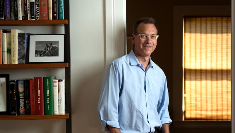 Igler stands next to a bookcase