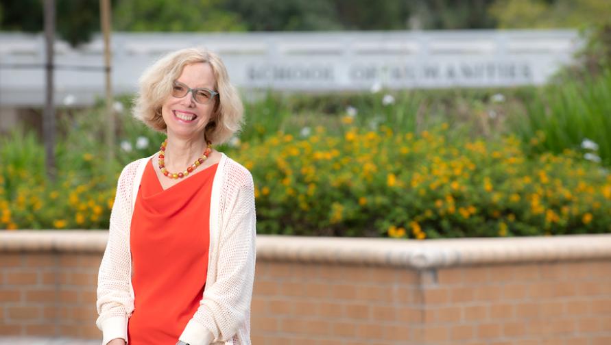 Julia Lupton wears an orange blouse at the School of Humanities courtyard