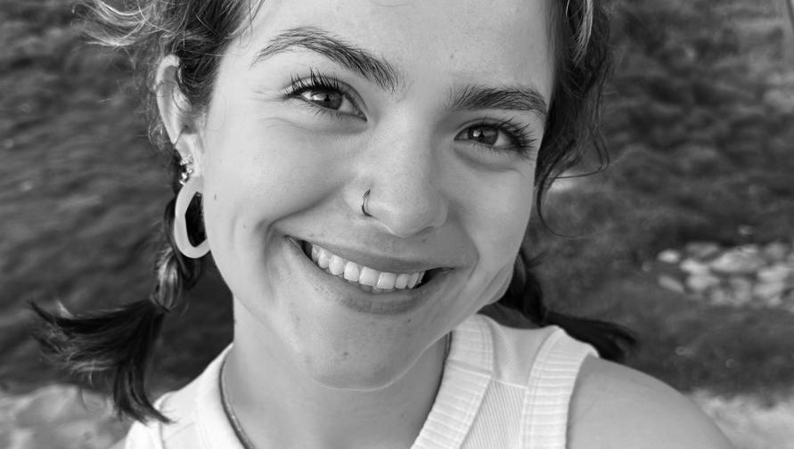 woman, early 20s, smiling at camera. black and white image.