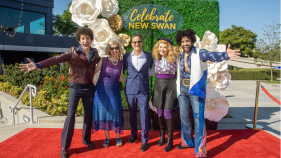 A group of people in costumes smile at the camera.