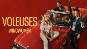 Three women smirking with one holding a weapon