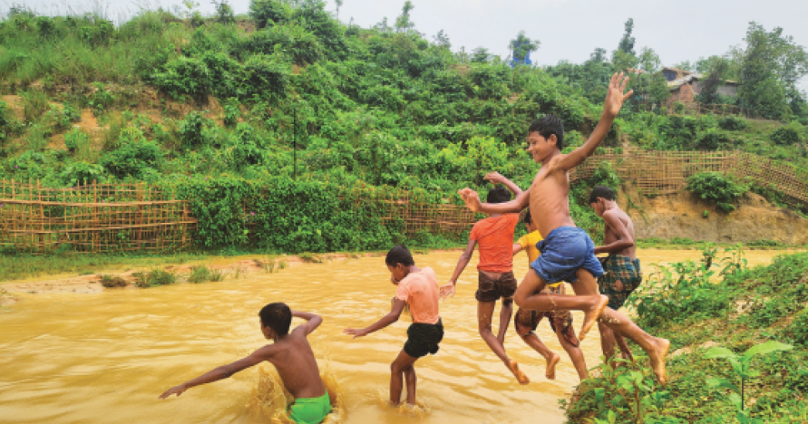 A group of boys jumping into the water.