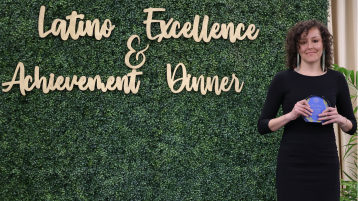 Jeanie Toscano UCI Spanish and Portuguese Ph.D. student wins LEAD Award. She is standing next to the LEAD sign.