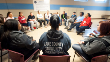 Image of incarcerated women sitting in charis in a circle during a course