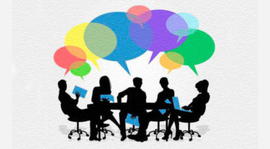 People sit at a desk holding books and talking represented by speech bubbles