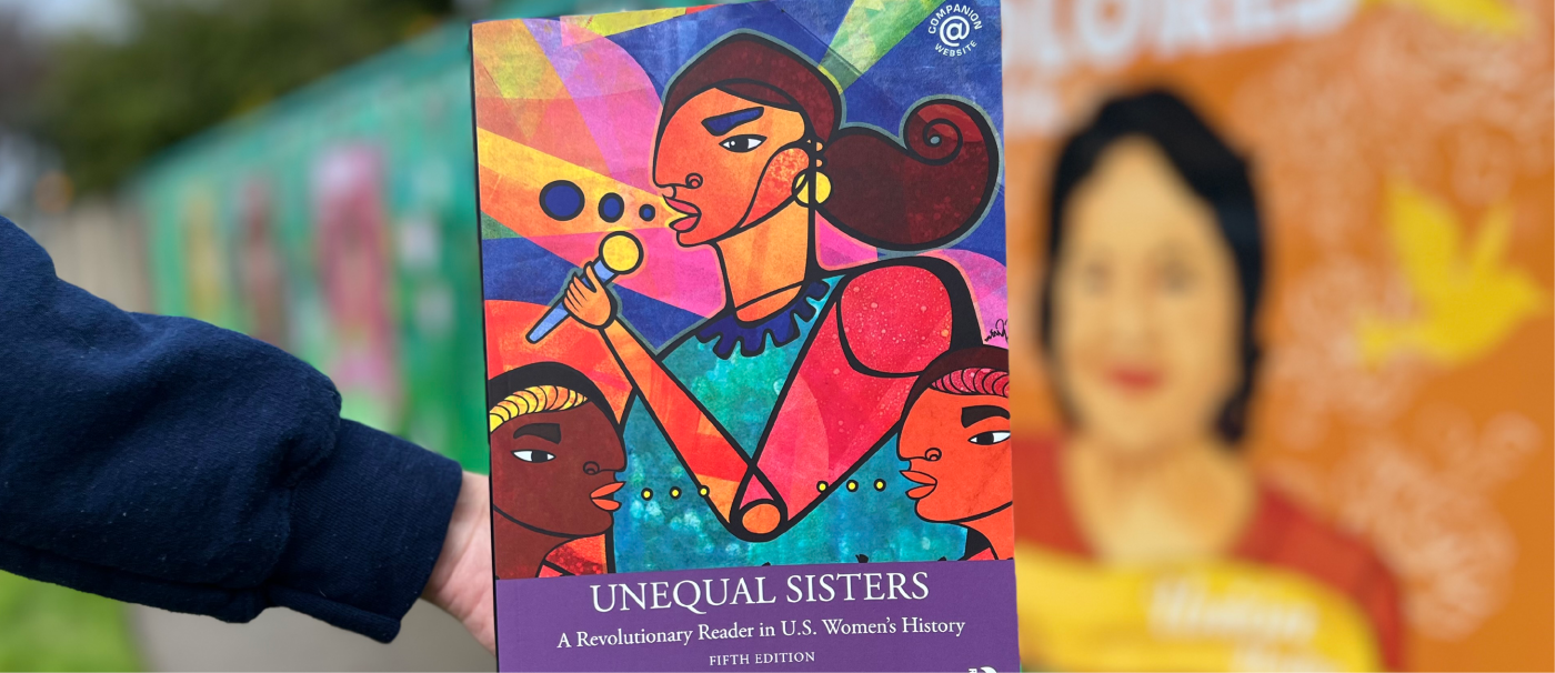 A hand is holding out the book "Unequal Sisters" 