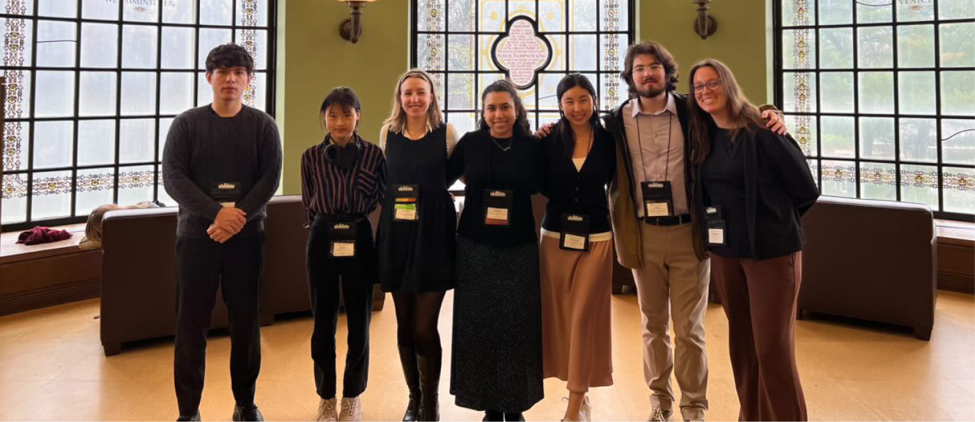 Students stand as a group in a museum.