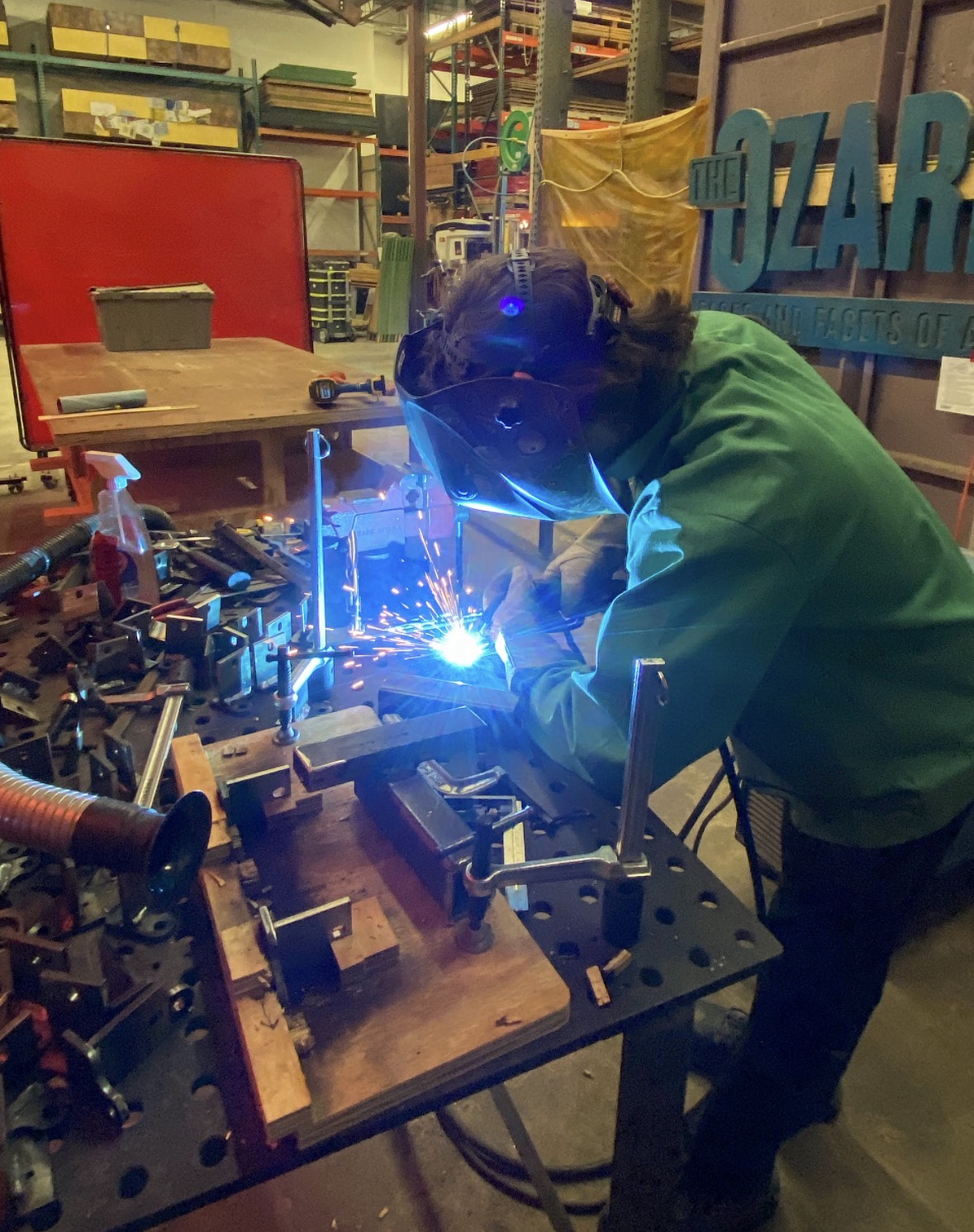 Joshua is welding something. 