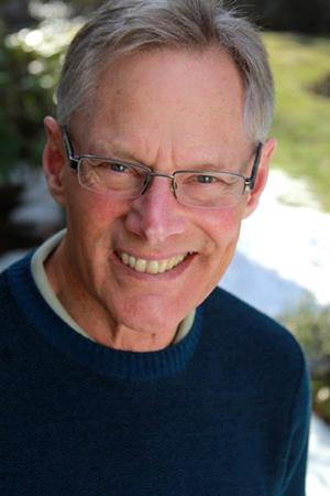 Photo of man's smiling face wearing in blue sweater