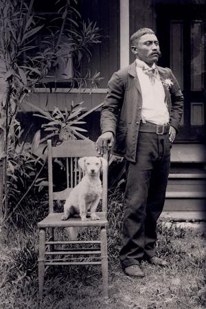 Image of a man posing next to a dog on a chair