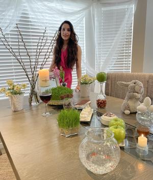 Erisa Taghizadeh standing by her Haft-sin table