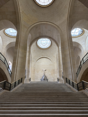 One large, tall hallway in the Louvre.