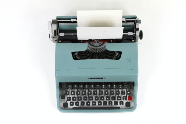 green typewriter with sheet of paper