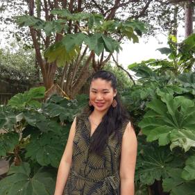 Larissa Fong smiling with foliage in the background