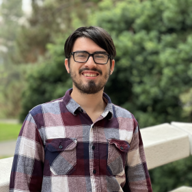 a man smiling in plaid shirt