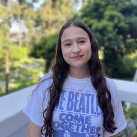 a woman in a Beatles band t-shirt, smiling