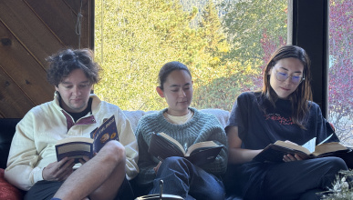 Herschel Uchitel, Zoe Adams, Emma Boyles sitting and reading together on a couch