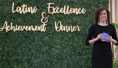 Jeanie Toscano UCI Spanish and Portuguese Ph.D. student wins LEAD Award. She is standing next to the LEAD sign.